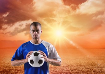 soccer player with ball on his hands in the sunset