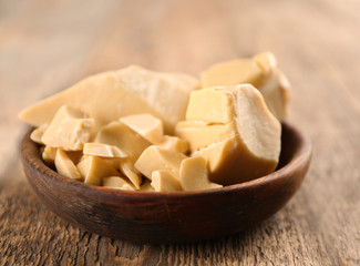 Bowl with cocoa butter on wooden table