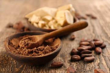 Composition with cocoa butter, powder and beans on wooden background
