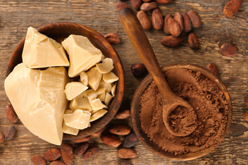 Composition with cocoa butter, powder and beans on wooden background