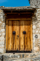 Wooden door with traditional serbian door knobs at The Old Town of Pocitelj, Bosnia and Hezegovina