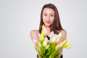 Young beautiful woman with a bouquet of tulips