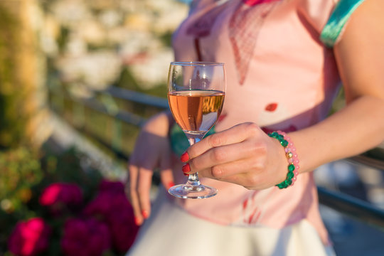Woman holding glass of rose wine