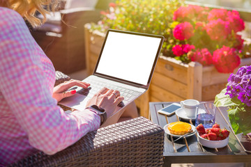 Naklejka na ściany i meble Girl working with laptop in outdoor cafe