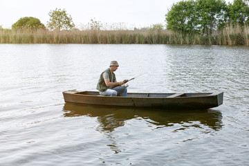 Fototapeta na wymiar man in small boat on fishing day.