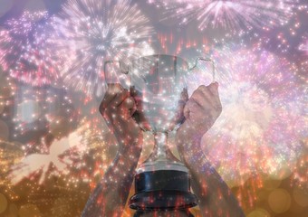 business hand with trophy, gold background and fireworks