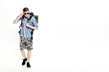 Young hiker in sunglasses with  backpack on  white background