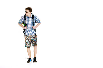 Naklejka premium Young hiker in sunglasses with backpack on white background