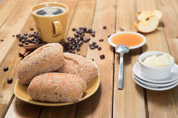Crispy rolls with butter, apple jelly and hot coffee for breakfast