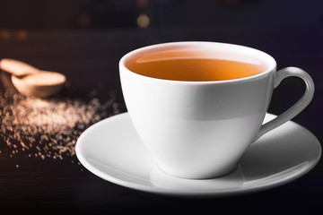 Hot Tea Cup And Cane Sugar. Splash On Dark Or Black Background