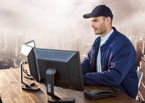 Security man on computer over large city