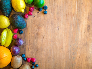 Mixed fruit with kiwi, raspberry, blueberry, lime, cherry. Top view on wooden table