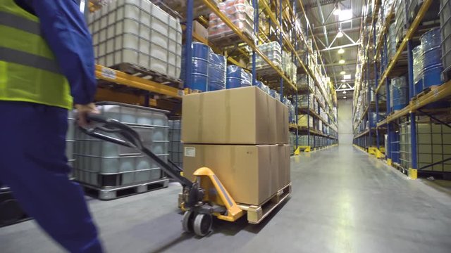 Warehouse worker moves cart with merchandise