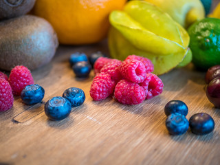 Mixed fruit with starfruit, raspberry, blueberry, cherry on wooden table