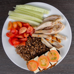 Healthy salad bowl with tomatoes, chicken on wooden background