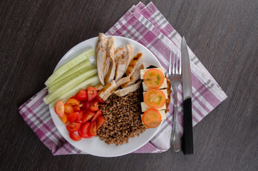 Fototapeta na wymiar Healthy salad bowl with tomatoes, chicken on wooden background
