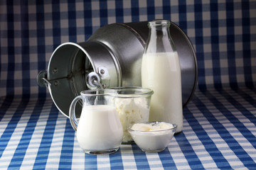milk products - tasty healthy dairy products on a table on: sour cream in a white bowl, cottage cheese bowl, cream in a a bank and milk jar, glass bottle and in a glass