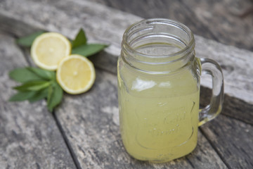 Obraz na płótnie Canvas Lemon juice in jar, decorated with fresh lemons and mint leaves.