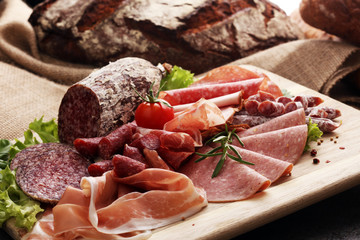 Food tray with delicious salami, pieces of sliced ham, sausage, tomatoes, salad and vegetable - Meat platter with selection