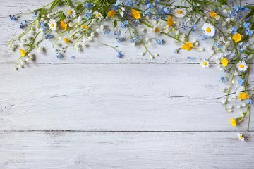 Fotobehang Lentebloemen van lelietje-van-dalen, vergeet me niet, madeliefjes op een houten achtergrond © tachinskamarina