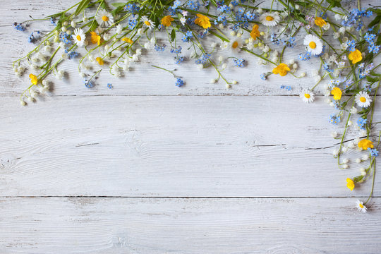 Spring flowers of lilies of the valley, forget me not, daisies on a white  wooden background