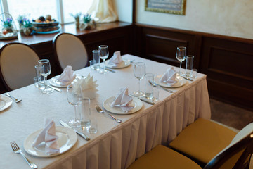 Plate with fork, knife and napkin served on the wedding table, all ready for the holiday.