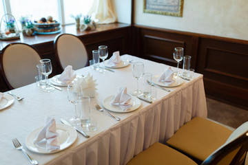 Plate with fork, knife and napkin served on the wedding table, all ready for the holiday.