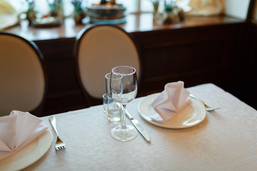 Plate with fork, knife and napkin served on the wedding table, all ready for the holiday.