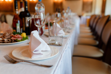 Plate with fork, knife and napkin served on the wedding table, all ready for the holiday.