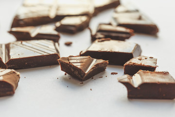 Chocolate pieces on white, selective focus, macro perspective