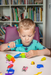 cute little boy playing with plasticine