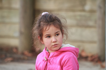 outdoor portrait of young happy child girl playing in park on natural background