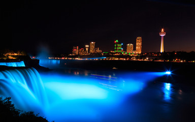 Fototapeta na wymiar Niagara Falls illuminated at night with multicolored lights