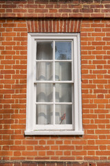 White vintage wooden window on a restored red brick wall