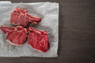 Raw Bone-in Rib eye Steak on wooden background