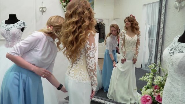 girlfriends chooses wedding gown at boutique