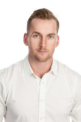 Obraz premium Handsome tan blonde man standing against a white background, wearing a white dress shirt.