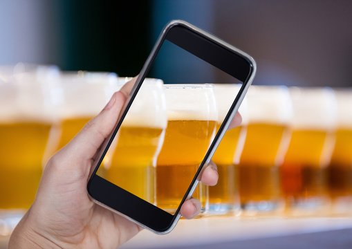 Hand of person taking a picture of beers  with her smartphone