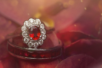red gemstone ring on rose