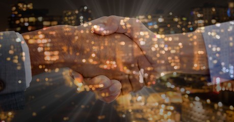 handshake foreground. Overlap with city at night