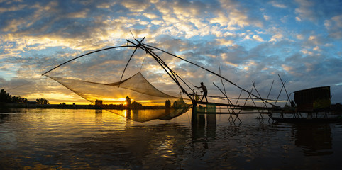 Fototapeta na wymiar Sunrise scene in Tha La cultivation field with fishing net in Chau Doc, An Giang province, South Vietnam