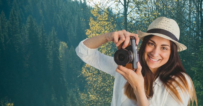 Happy casual woman taking a picture in front of wood background