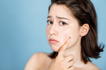 young woman who checks her skin. acne treatment.