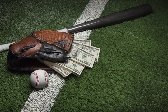 Baseball mitt full of money on a field with a bat and ball
