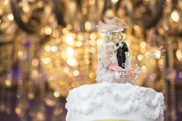 Bride and groom doll on cake in wedding ceremony