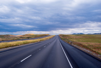 Long straight road going cloudly horizon in California