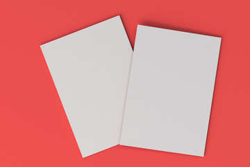 Two blank white closed brochure mock-up on red background