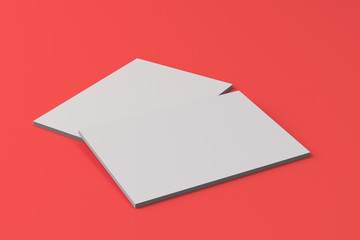 Two blank white closed brochure mock-up on red background