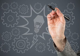 Hand writing lightbulb and cog  doodles against grey background