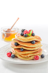 Delicious american pancakes with maple syrup and berries